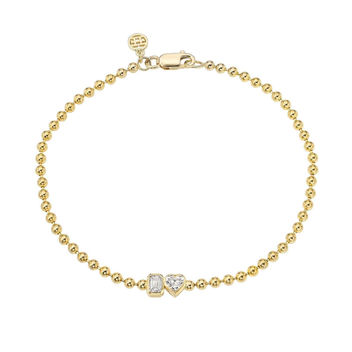 The Emerald & Heart Toi Et Moi Bracelet from Janet Heller Fine Jewelry, is crafted in 14KT gold and features heart and emerald-cut diamonds. The diamonds are 0.15 carats each and are in bezel settings. The bracelet can be worn on its own or stacked with others.