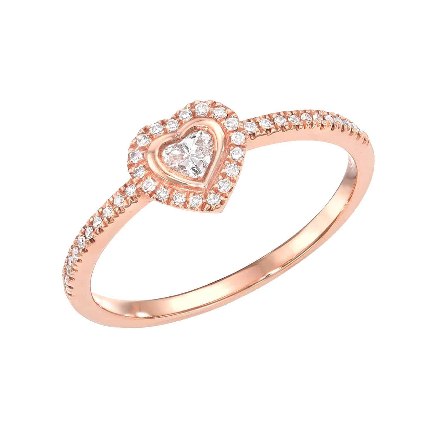 The Diamond Heart Halo Ring from Janet Heller Fine Jewelry is crafted in 14KT gold. It showcases a diamond band with a heart-shaped diamond center, encircled by round diamonds. The ring can be stacked or worn on its own.