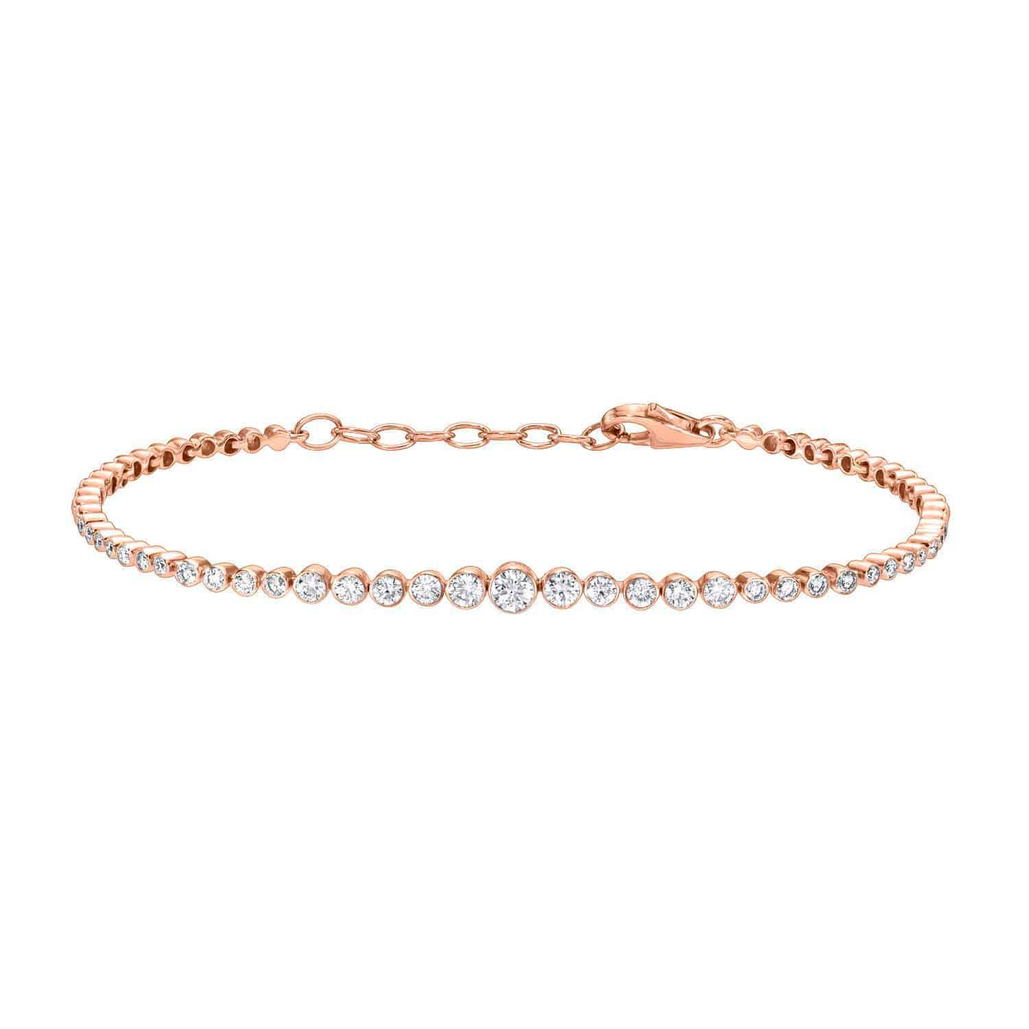 The Graduating Bezel Diamond Bracelet is a delicate rose gold piece with a row of sparkling diamonds, featuring an adjustable chain and clasp closure for an elegant look.