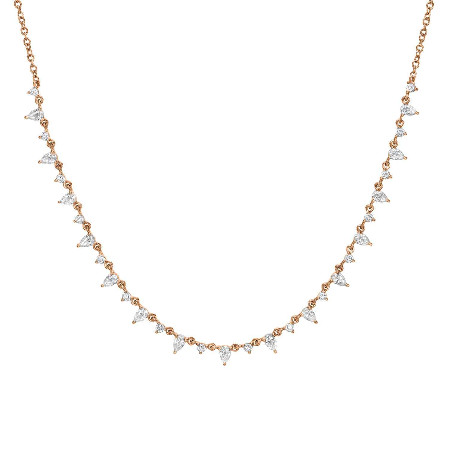 The Pear Shaped Diamond Necklace is a delicate gold chain featuring small, evenly spaced teardrop diamonds. These diamonds create a shimmering and elegant look as they lie along the chain with a gentle curve.