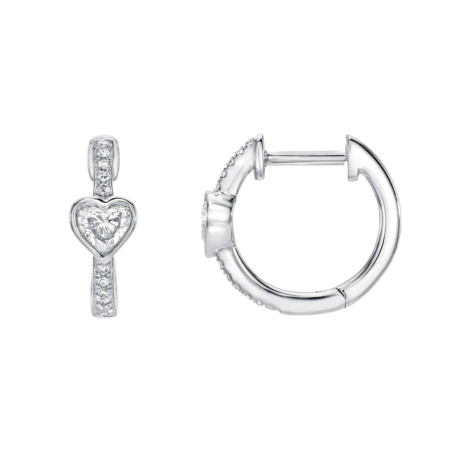 The Diamond Amore Huggies are two silver hoop earrings; one displays a heart-shaped gemstone and small gems along the hoop, while the other shows its clasp from the side. Both exude a sparkling, elegant design characteristic of fine jewelry.