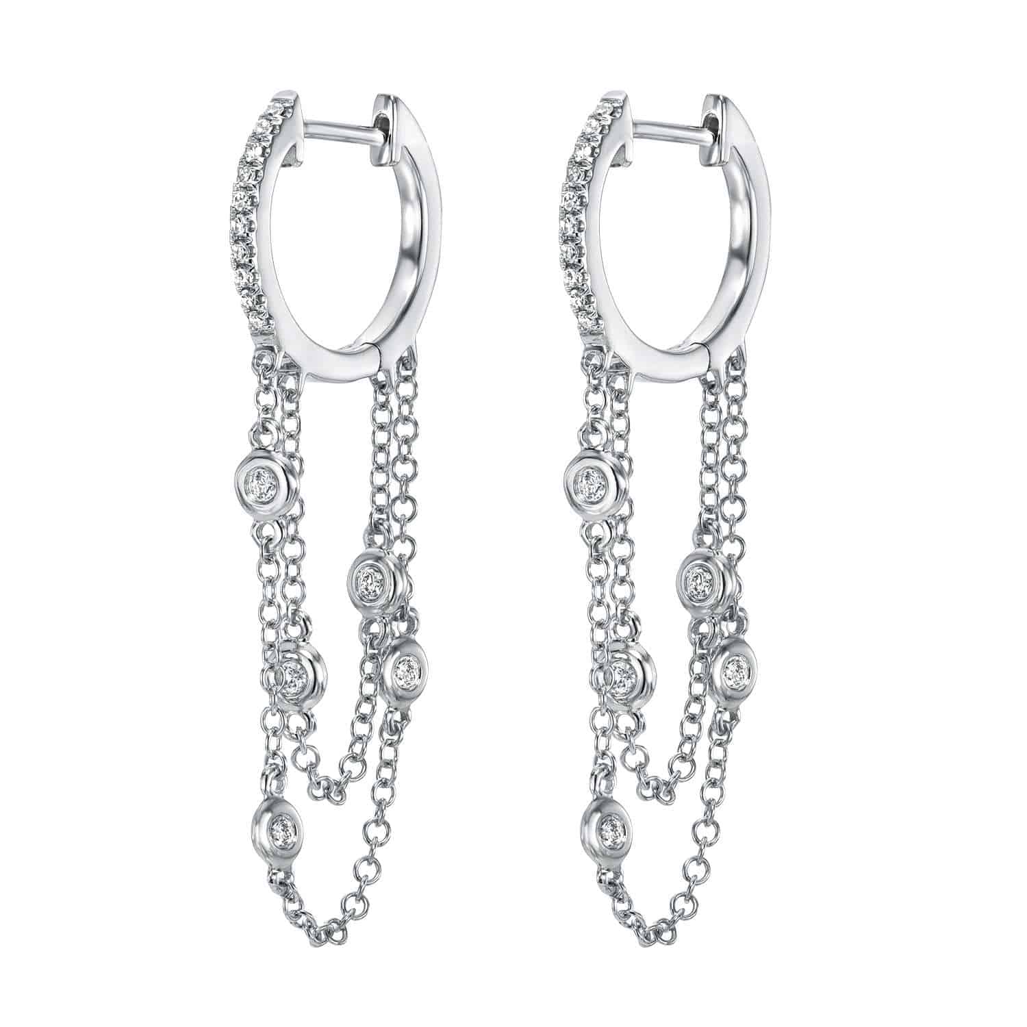 The Diamond Waterfall Huggies by Janet Heller Fine Jewelry are elegant silver hoop earrings featuring multiple dangling chains, each adorned with small, circular clear stones. They beautifully blend the simplicity of hoops with the ornate detail of layered chains.