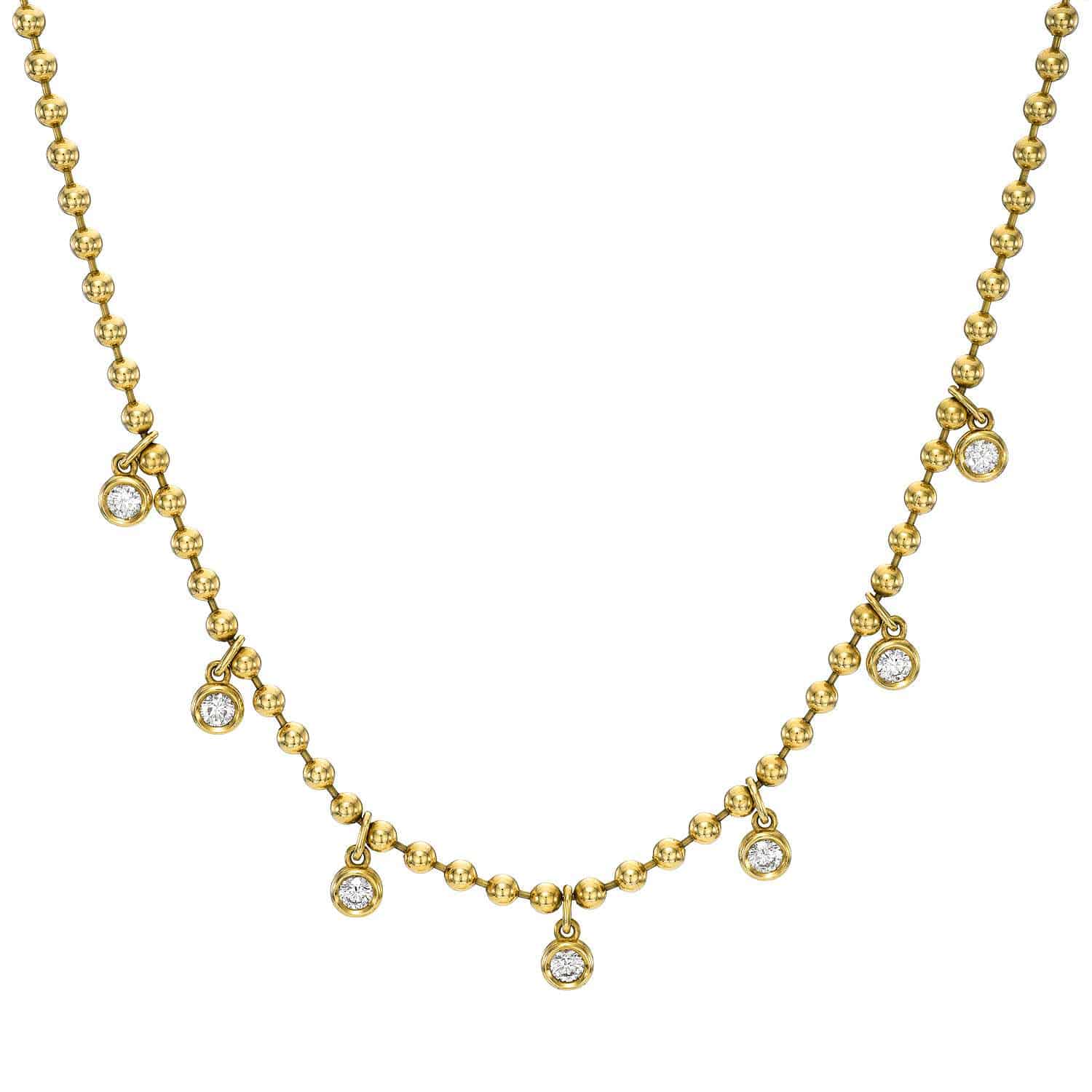 Experience the elegant simplicity of the Diamond Kinsley Necklace by Janet Heller Fine Jewelry, showcasing a gold chain with small round beads and seven evenly spaced dangling clear gemstone pendants.