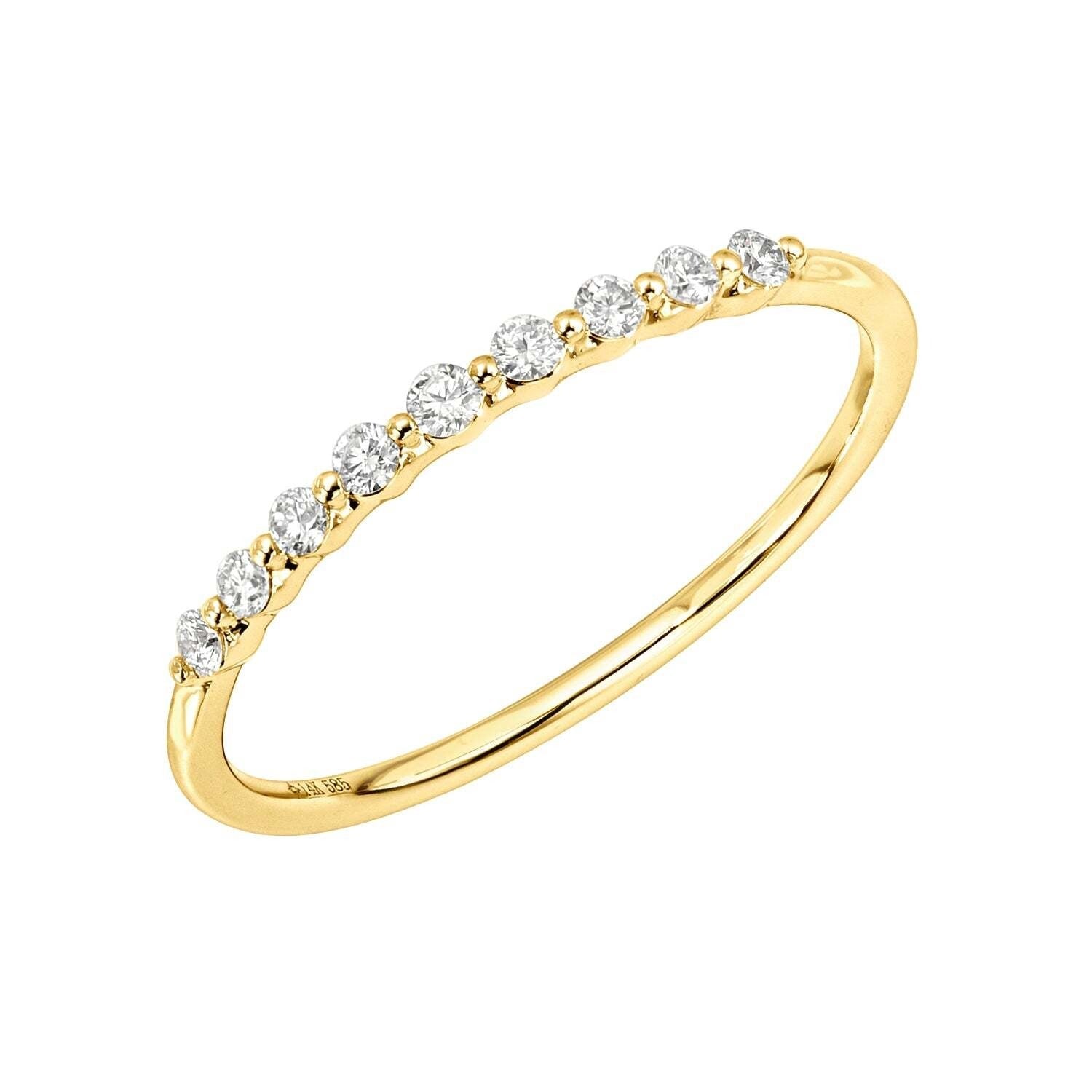The 9 Diamond Delilah Ring is a thin 14KT gold band with a row of nine small, round white diamonds along the top—perfect as a delicate stacking ring for your fine jewelry collection.