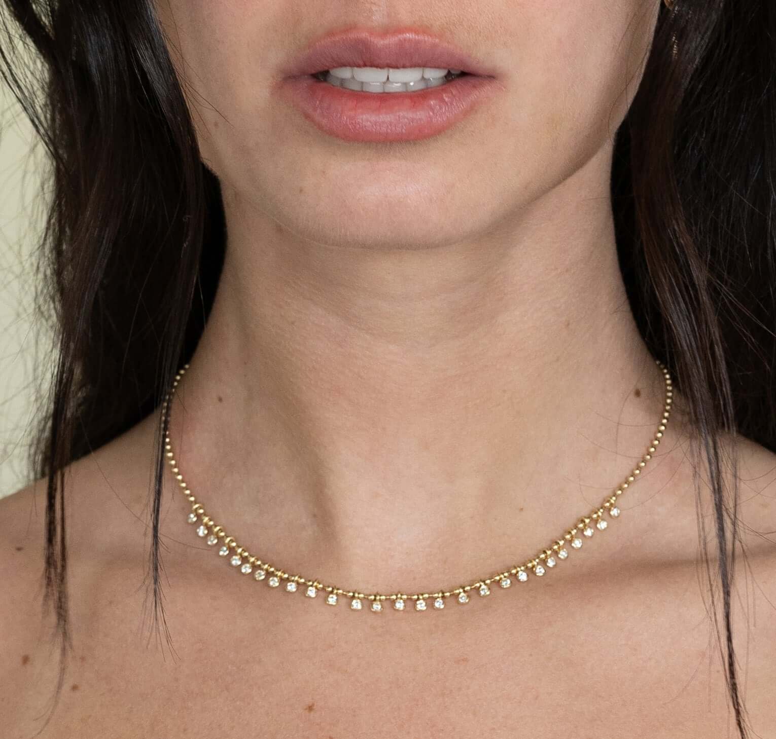 The Diamond Eisley Necklace from Janet Heller Fine Jewelry is crafted in 14KT gold.  It features a chain of gold beads with dangling round diamonds.  The necklace can be worn on its own or layered with other necklaces.