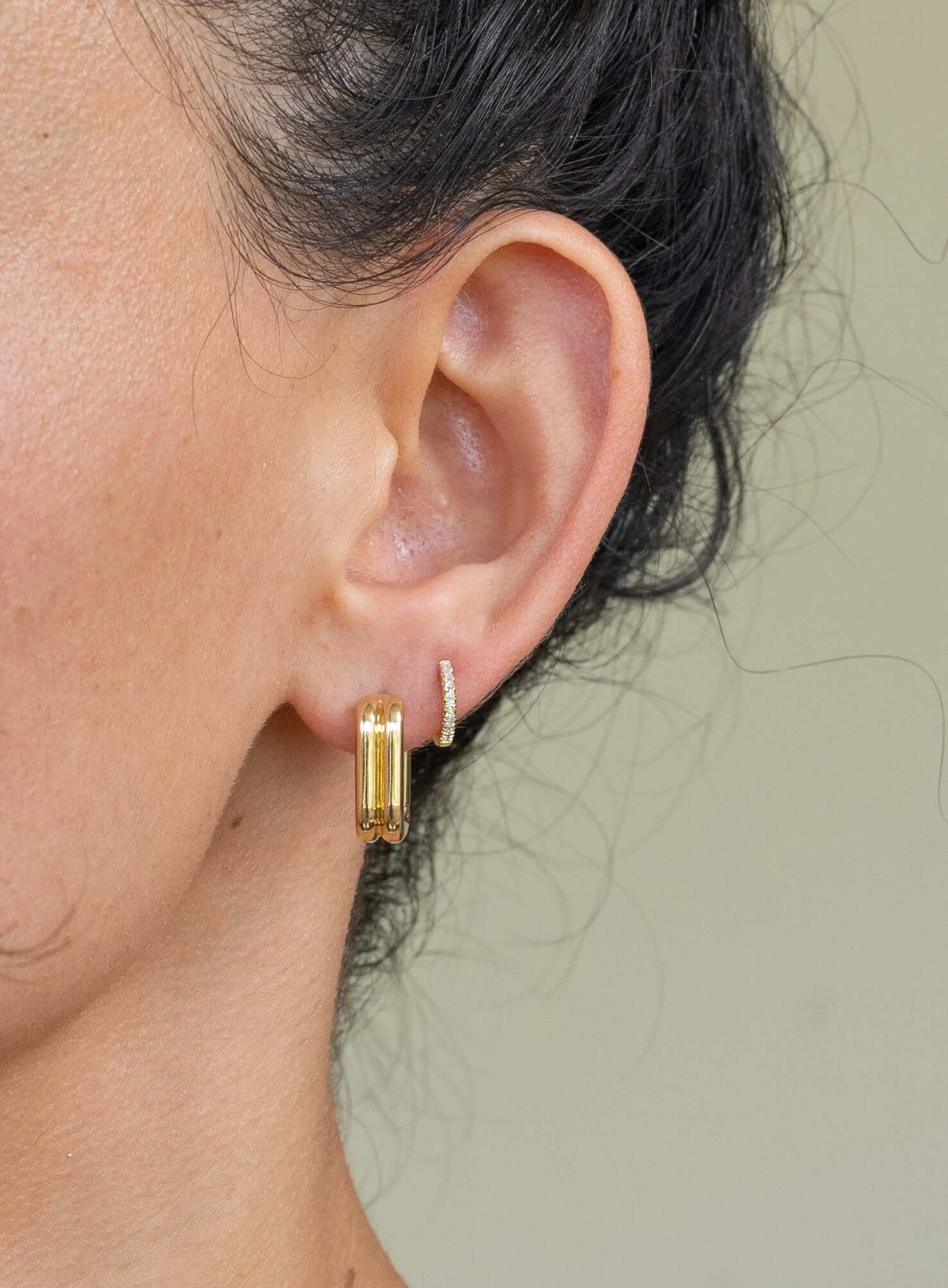 The Small Rectangle Hoop Earrings from Janet Heller Fine Jewelry are crafted in 14KT gold. The rectangles sharp edges are softened by rounded edges. The earrings can be worn on their own or layered along the ear with other earrings.