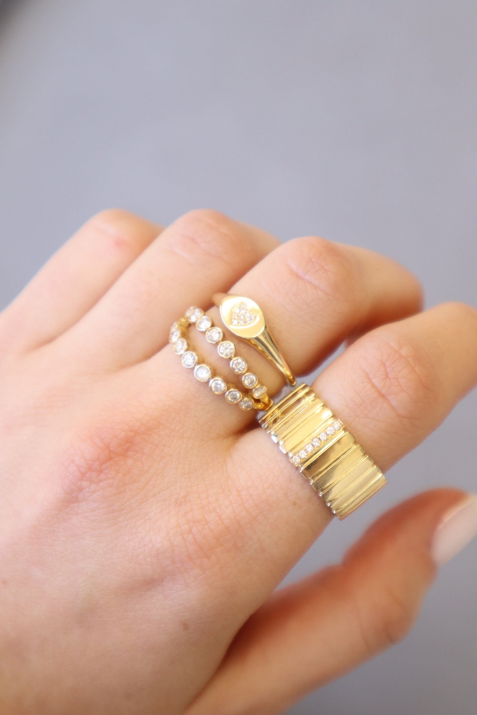The Chunky Diamond Bars Ring from Janet Heller Fine Jewelry is crafted in 14KT gold. The ring features a ribbed wide band with a row of 7 diamonds set across the top. The ring can be stacked or worn on its own.