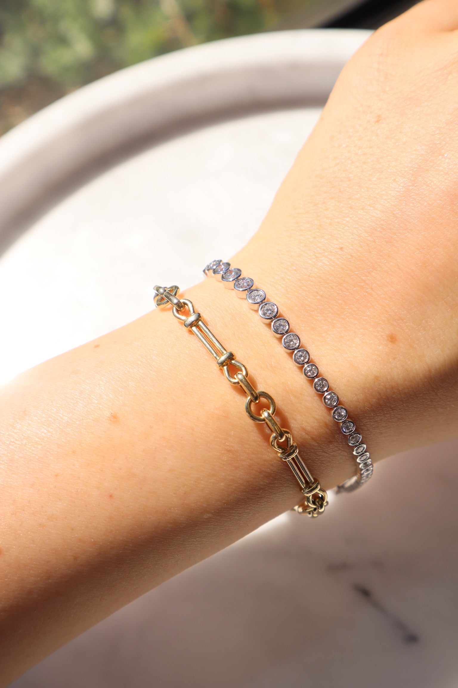 The Lisbon Bracelet from Janet Heller Fine Jewelry, is a 14KT gold chain bracelet with circular links and is embedded with small, round diamonds. The bracelet can be worn on its own or stacked with other bracelets.
