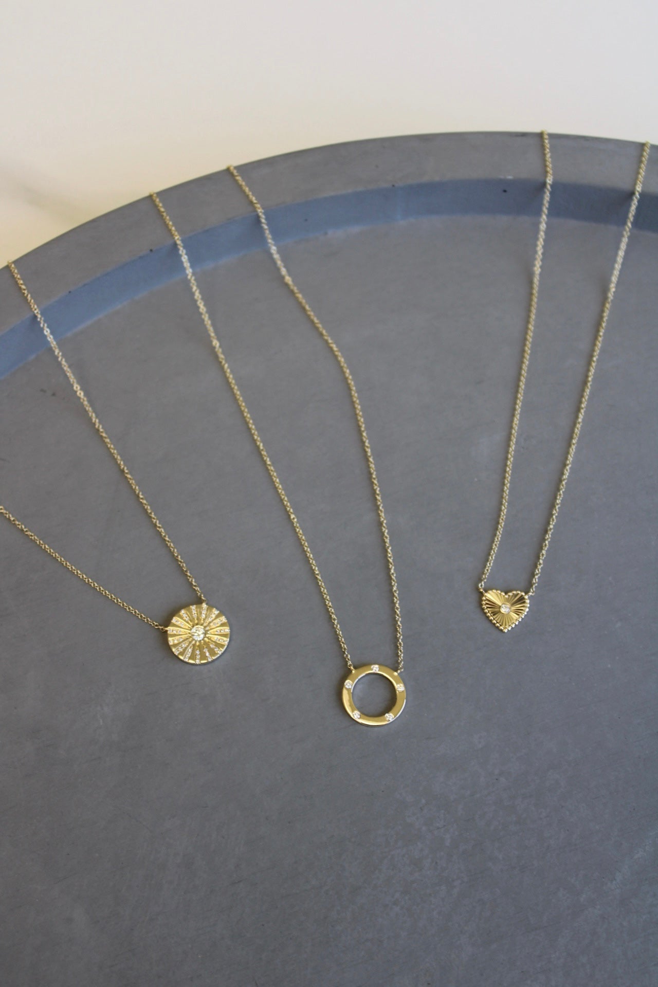 The Mini Diamond Ridge Heart Necklace from Janet Heller Fine Jewelry is crafted in 14KT gold. The Necklace features a sunburst pendant with a center diamond and a beaded edge. The necklace can be worn alone or layered with other chains and necklaces.