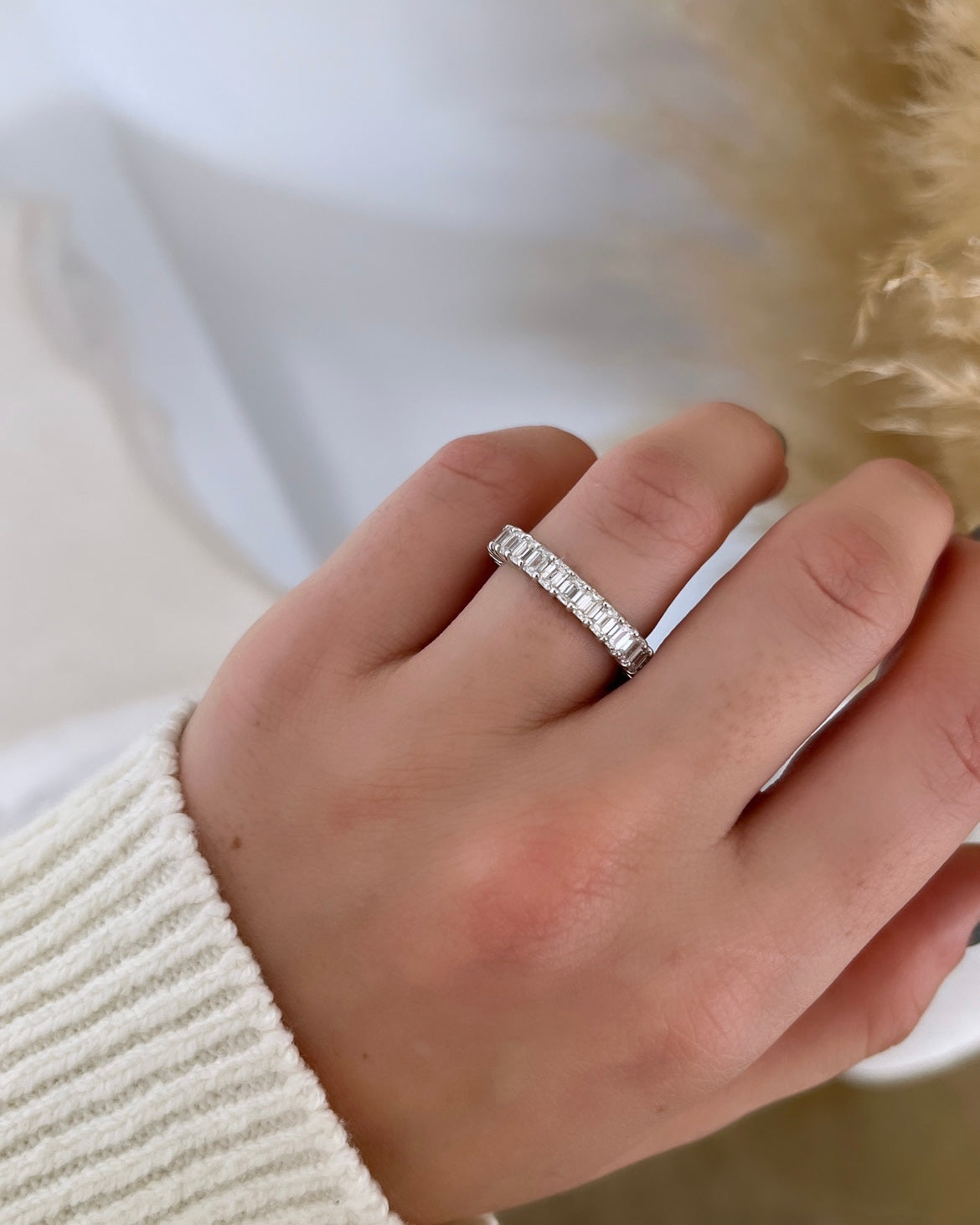 The Full Lab Grown Diamond Eternity Ring from Janet Heller Fine Jewelry, crafted in 18KT gold, features evenly spaced diamonds offered in various shapes and custom carat weights. The color of the diamonds is F and the clarity is VS. This is the perfect wedding band to be worn alone or stacked with your engagement ring.