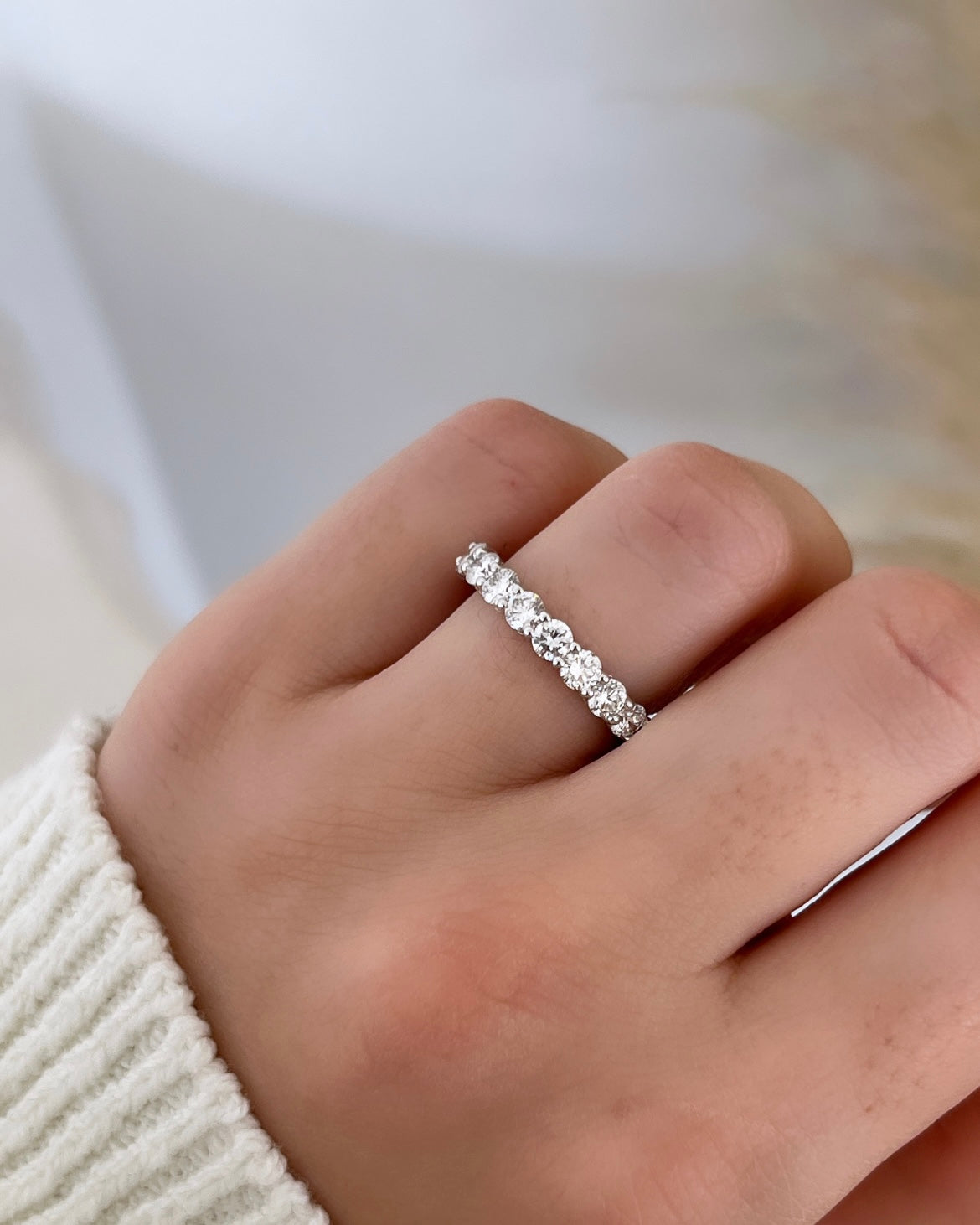 The Full Lab Grown Diamond Eternity Ring from Janet Heller Fine Jewelry, crafted in 18KT gold, features evenly spaced diamonds offered in various shapes and custom carat weights. The color of the diamonds is F and the clarity is VS. This is the perfect wedding band to be worn alone or stacked with your engagement ring.