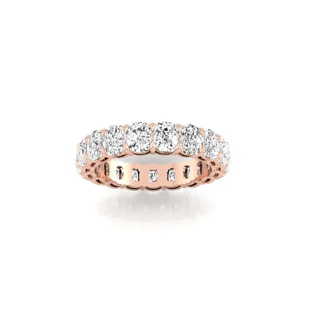 The Full Diamond Eternity Ring in 18KT rose gold showcases a continuous loop of prong-set, round-cut diamonds with F Color and VS Clarity, featuring intricate edge detailing to enhance its brilliance and luxury.