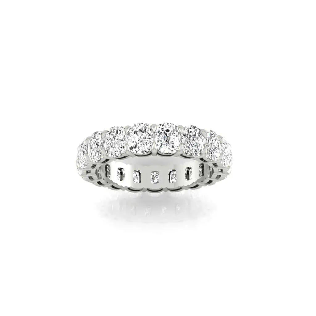 The Full Lab Grown Diamond Eternity Ring from Janet Heller Fine Jewelry, crafted in 18KT gold, features evenly spaced diamonds offered in various shapes and custom carat weights. The color of the diamonds is F and the clarity is VS. This is the perfect wedding band to be worn alone or stacked with your engagement ring.