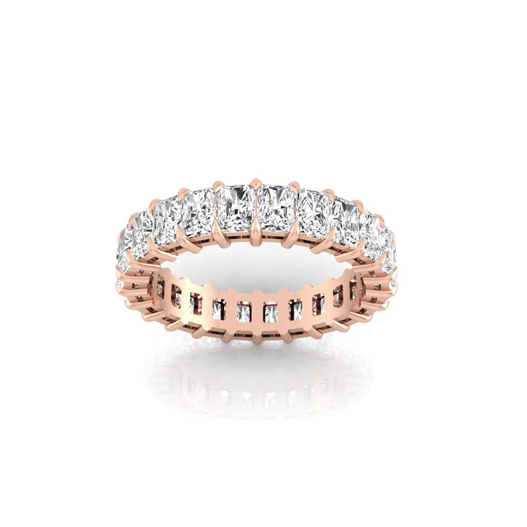 The Full Lab Grown Diamond Eternity Ring in 18KT rose gold features radiant-cut diamonds of F Color and VS Clarity encircling the band, presenting a luxurious and elegant design against a plain white background.