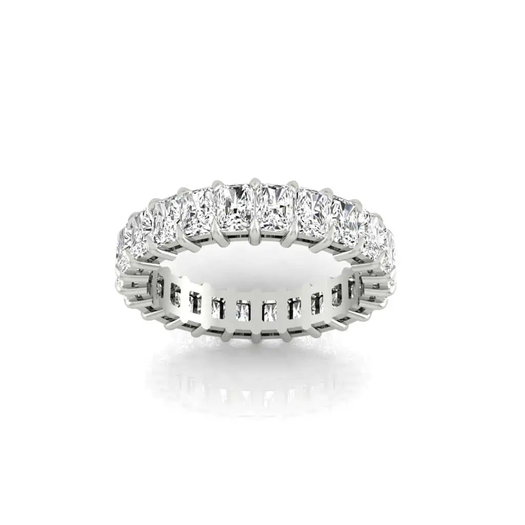 The Full Diamond Eternity Ring, with a row of rectangular, F Color gemstones in VS Clarity, sparkles brilliantly and is elegantly displayed from a slightly angled perspective against a white background.