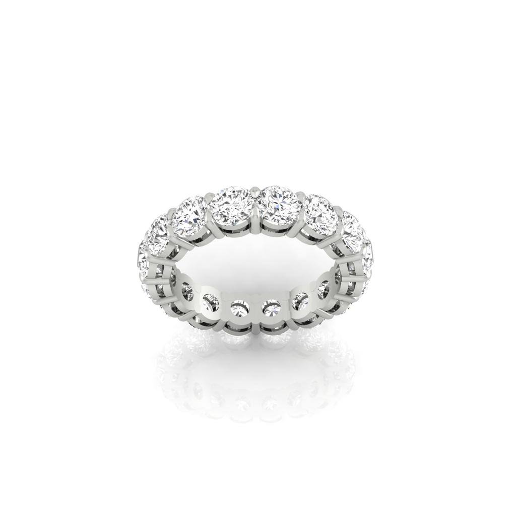 A Full Lab Grown Diamond Eternity Ring features F Color VS Clarity round-cut diamonds encircling the entire band. It stands upright on a reflective white surface, showcasing its symmetrical brilliance with 18KT gold elegance.