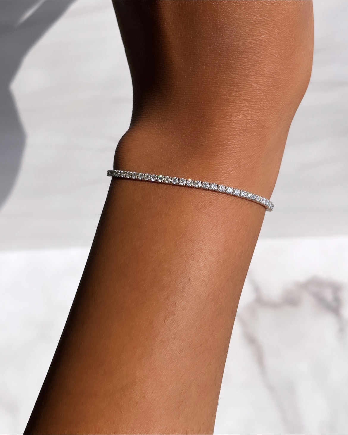 The 5ct Round Diamond Tennis Bracelet from Janet Heller Fine Jewelry is crafted in 14KT gold. The bracelet features small diamonds in a continuous line and is available in both lab grown and natural diamonds. The bracelet can be worn on its worn or layered with other bracelets.