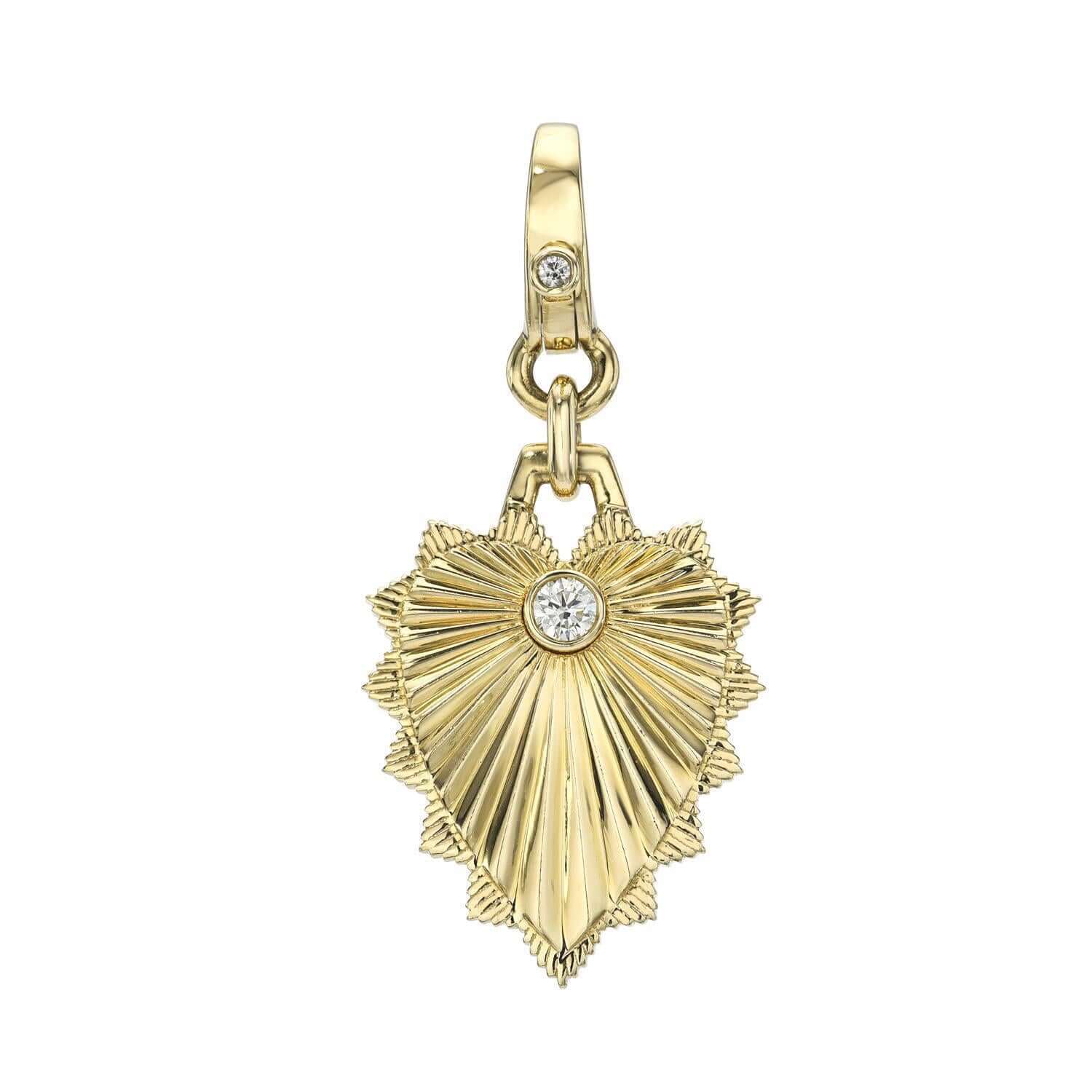 The Ribbed Diamond Heart Shield Charm necklace from Janet Heller Fine Jewelry features a ribbed design with scalloped edges and a diamond in the center of the pendant. It features a clasp with a single diamond so it can be clipped onto various Janet Heller Fine Jewelry chains.