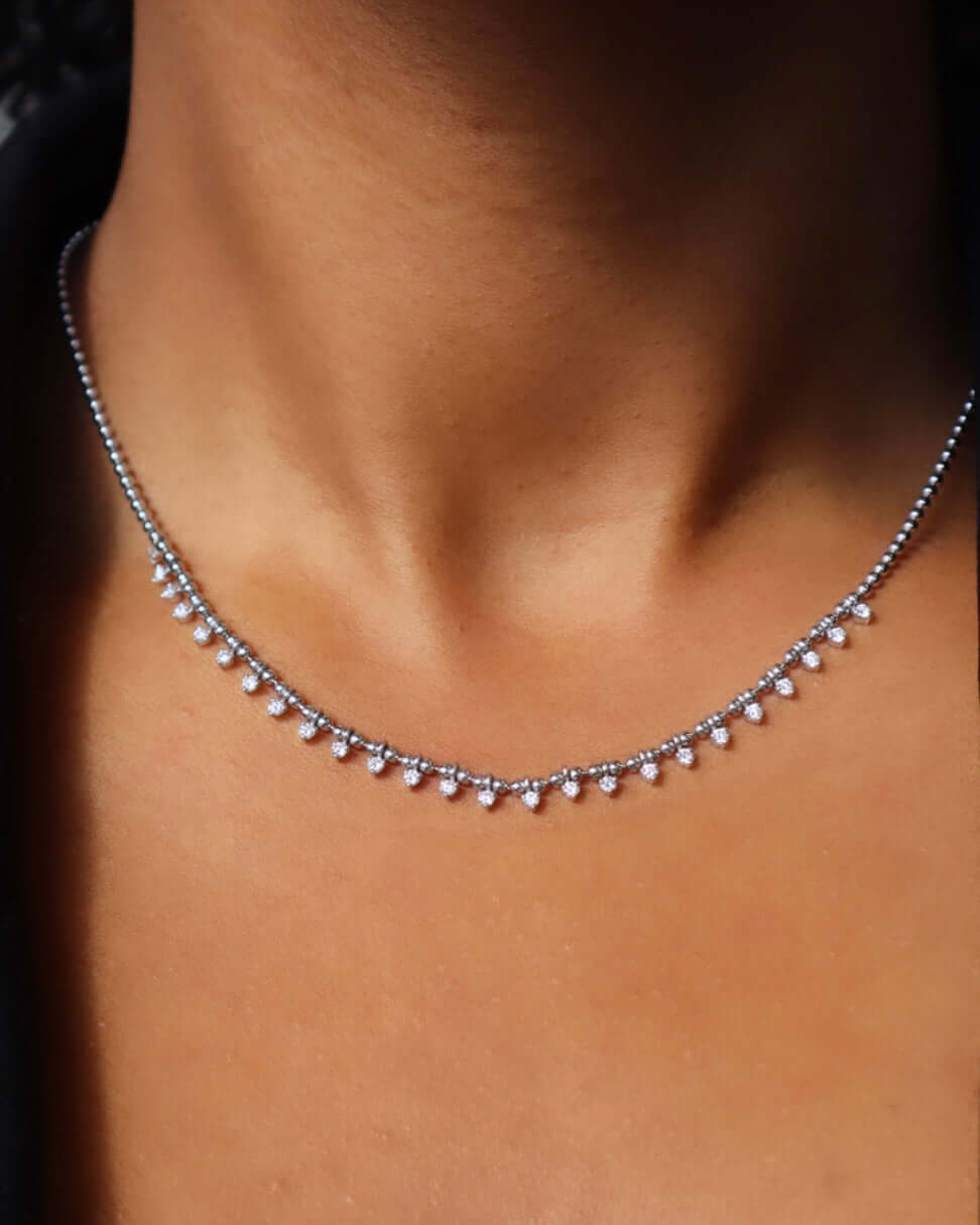 The Diamond Gisele Necklace from Janet Heller Fine Jewelry is crafted in 14KT white gold and is adorned with small dangling diamonds. The necklace can be worn on its own or layered with other chains.