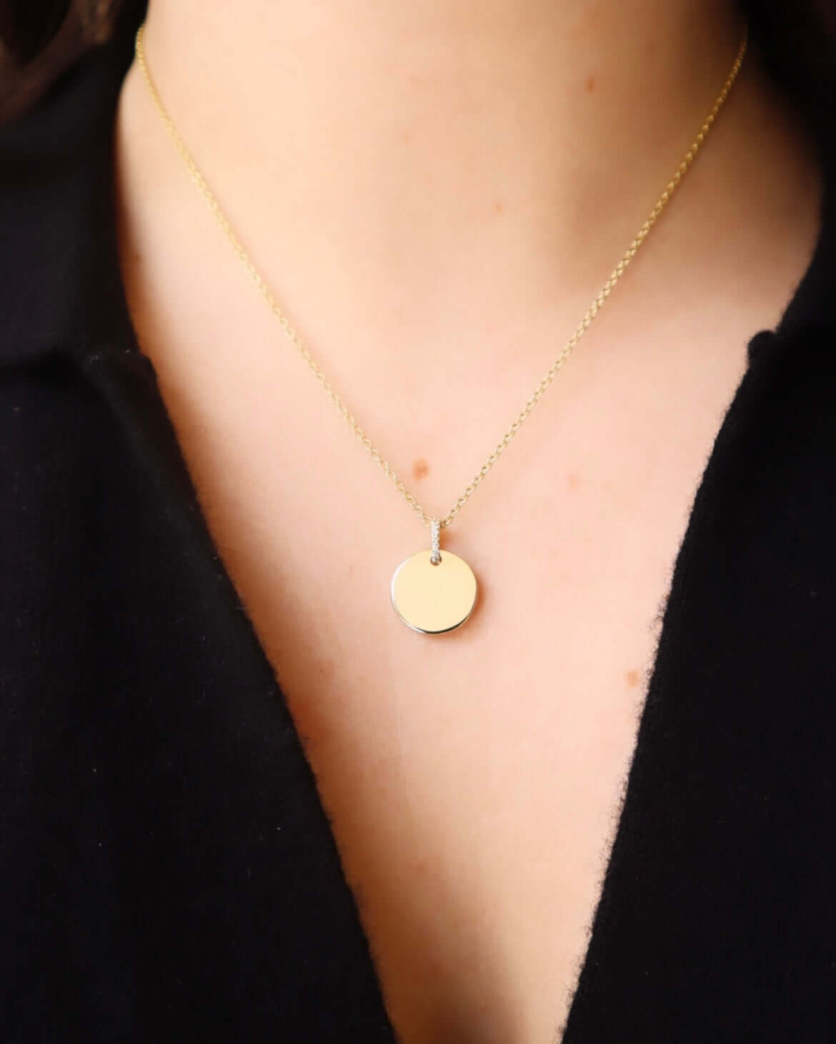 The Mini Round Engravable Pendant Necklace from the Janet Heller Fine Jewelry Sketch Collection, features a 14KT gold round charm and a diamond bale. The pendant is perfect for engraving a personalized keepsake.