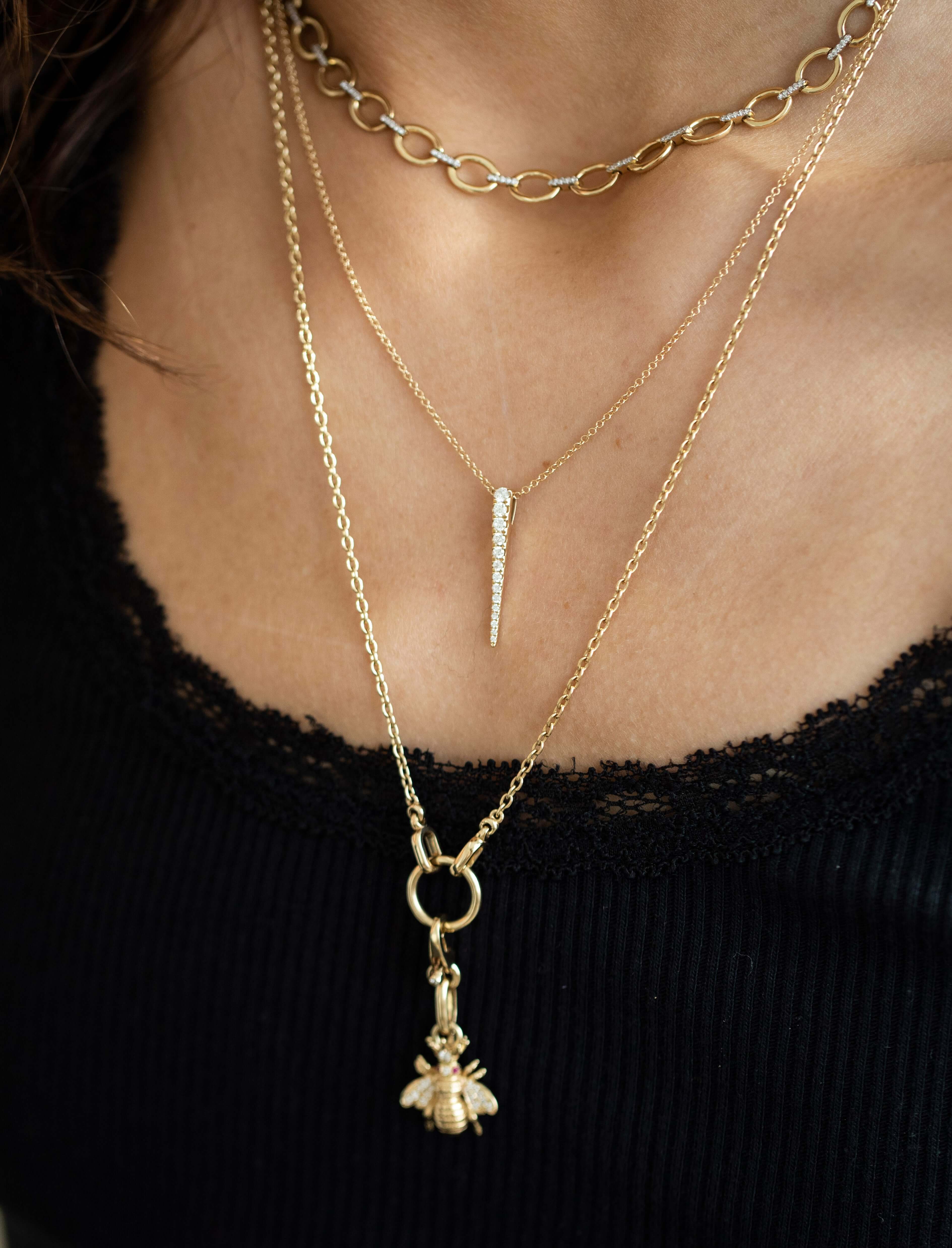 The Diamond Dagger Necklace from Janet Heller Fine Jewelry is crafted in 14KT gold and features small round diamonds on an adjustable chain.  The necklace can be worn alone or layered with other chains.
