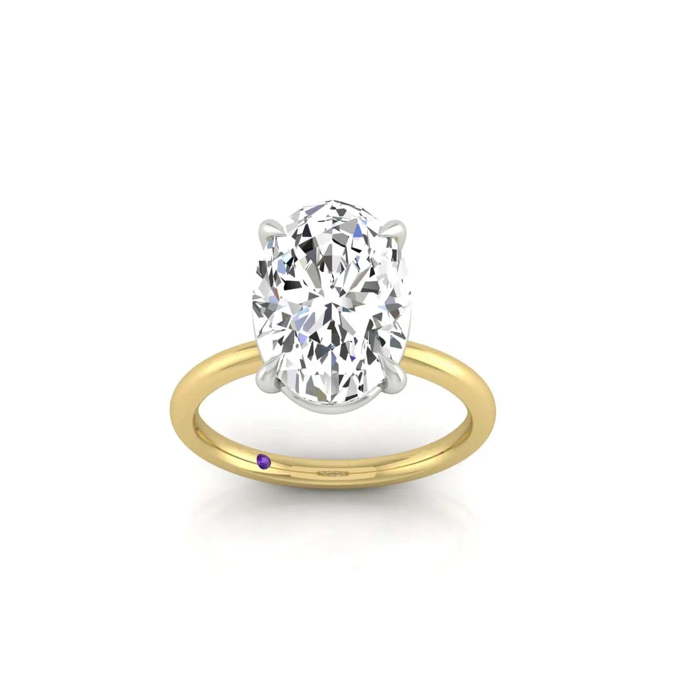 The Solitaire is an 18KT gold engagement ring featuring a stunning oval-cut diamond in a classic four-prong setting. Its polished band includes a small purple accent, enhancing its elegance against the white background.