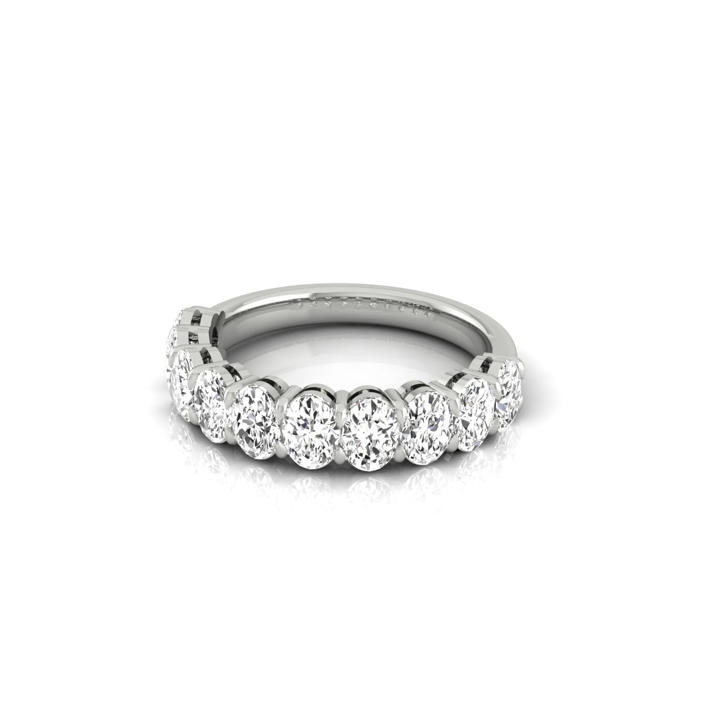 The Half Diamond Eternity Ring is a silver band graced with a row of round VS Clarity diamonds in prong settings, showcased on a white background. Its simple yet elegant design highlights the stones brilliance.