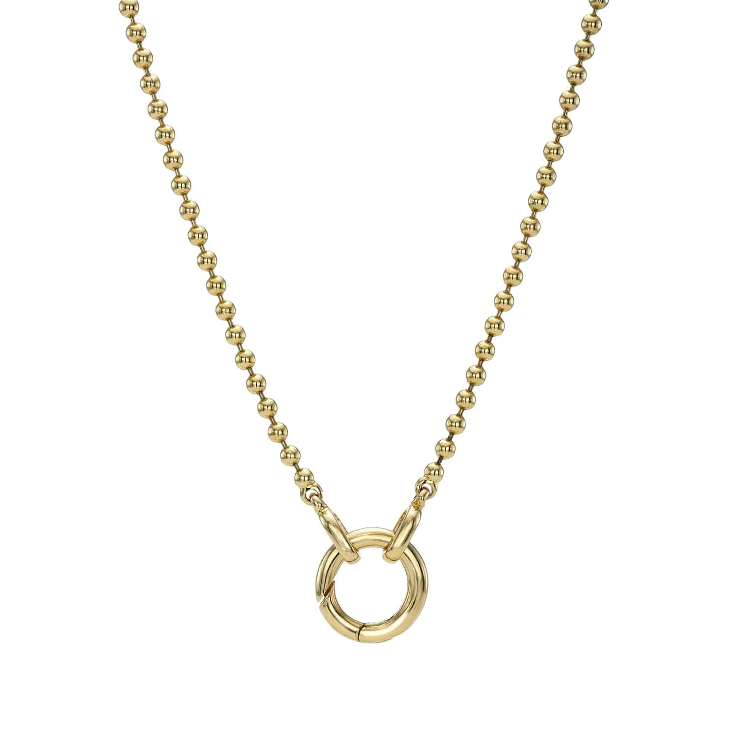 Close-up of the Amsterdam Chain from Janet Heller Fine Jewelry, featuring a gold beaded necklace with a round, textured circular pendant at the center and delicate jewelry charms, set against a plain white background.