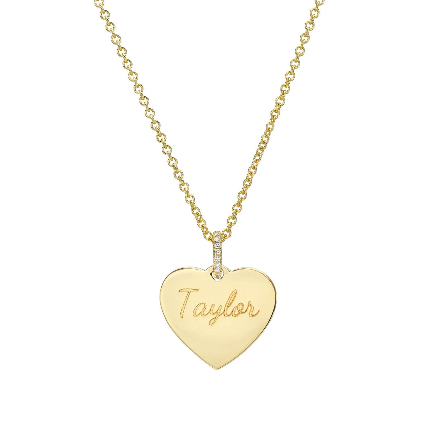 The Medium Heart Engravable Pendant Necklace is a gold chain necklace with a heart-shaped pendant engraved with Taylor in signature fonts. The pendant has a small vertical row of clear stones at the top, creating a personalized keepsake where it connects to the chain.