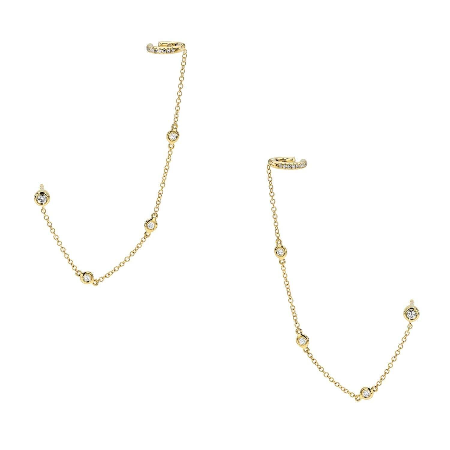 The Diamonds By The Yard Cuff Studs by Janet Heller Fine Jewelry are crafted in 14KT gold. The earrings feature two diamond cuffs with thin chains, adorned with evenly spaced round diamonds. The delicate studs can be worn alone or layered along the ear with other earrings.