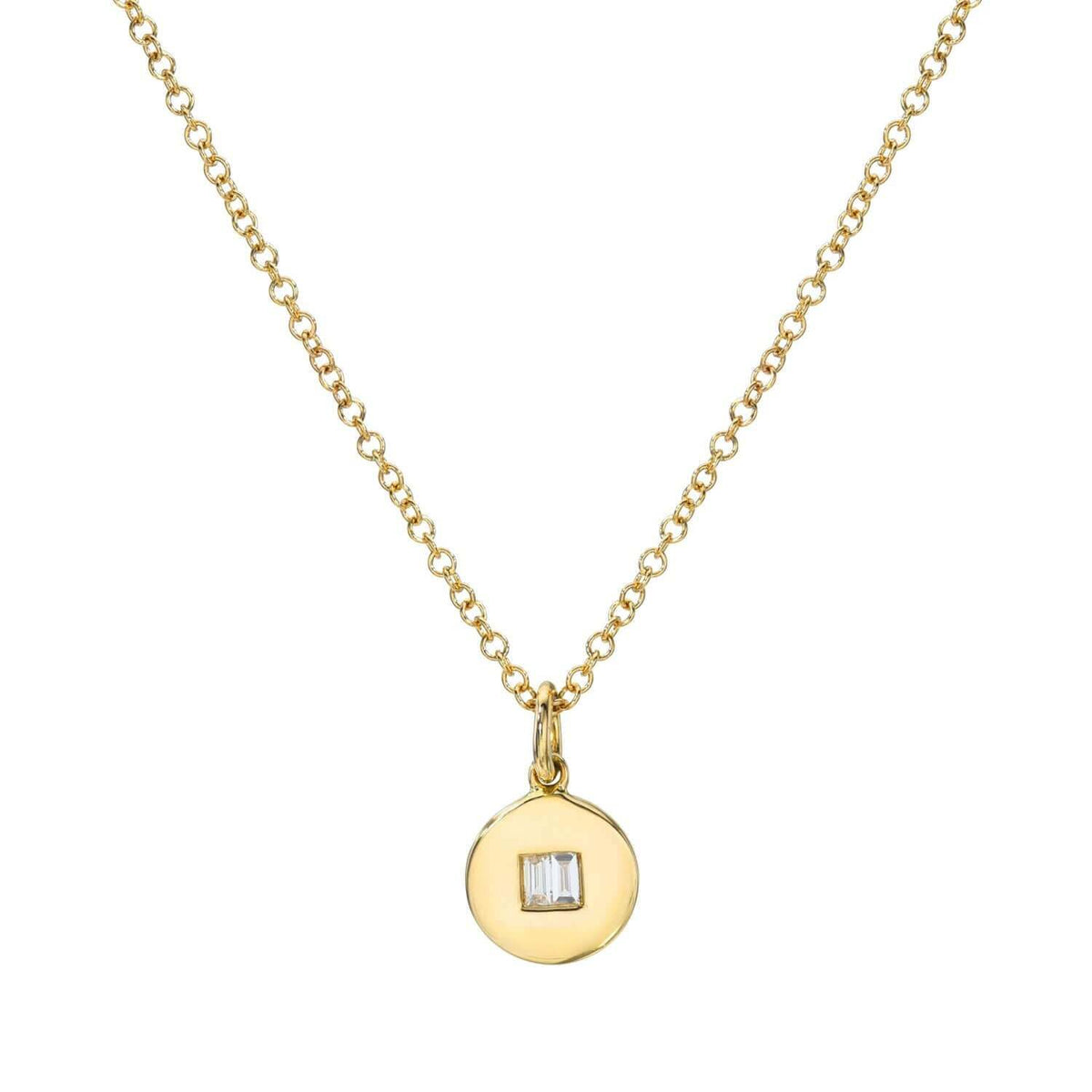 The Baguette Diamond Disc Necklace by Janet Heller Fine Jewelry features a round gold pendant with a small, square-cut clear gemstone at the center. Inquire for custom options. Shown on white background.