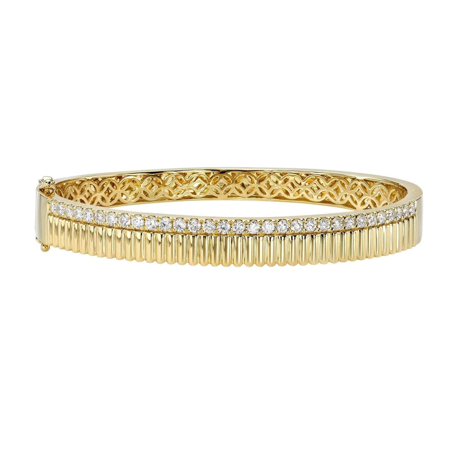 The Diamond Lucky Bangle from Janet Heller Fine Jewelry is crafted in 14KT gold. The bracelet features a row of small round diamonds on top of a ridged plain gold bottom.  The bangle can be worn on its own or stacked.