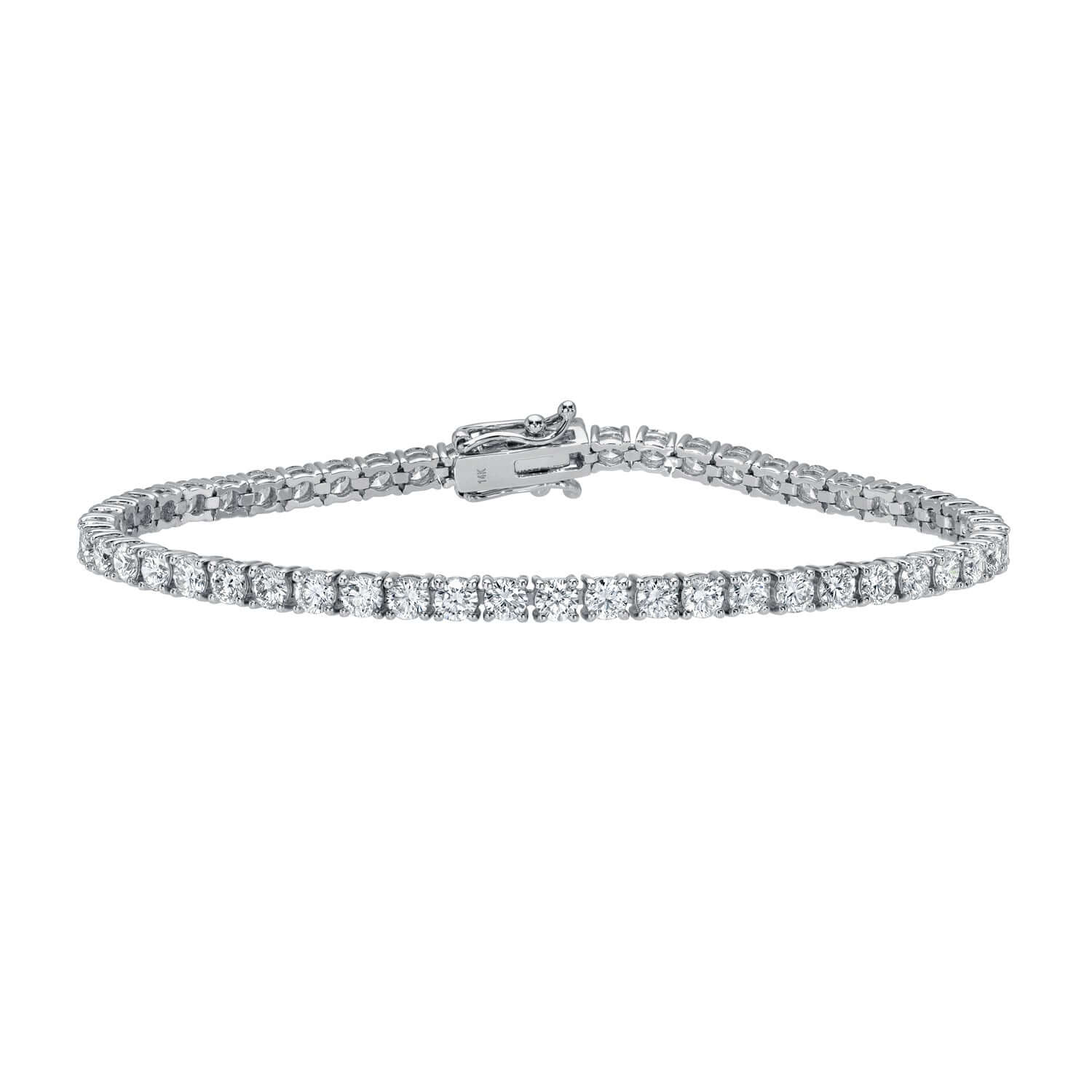 The 5ct Round Diamond Tennis Bracelet from Janet Heller Fine Jewelry features a sleek clasp and a row of sparkling, round-cut natural diamonds set in silver, displayed against a plain white background to highlight its elegance.