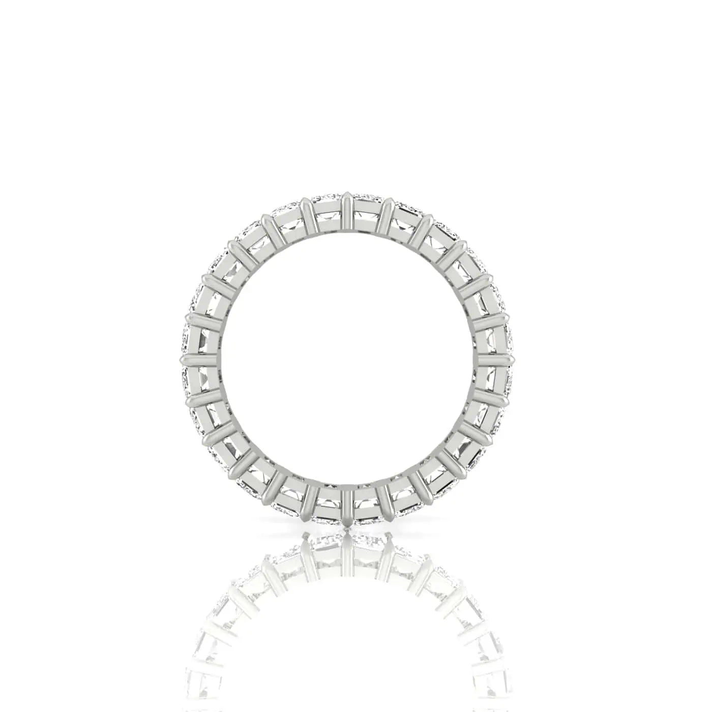 The Full Diamond Eternity Ring is showcased upright on a reflective surface, featuring a series of uniform prongs, each holding F Color and VS Clarity gemstones that encircle the entire band.