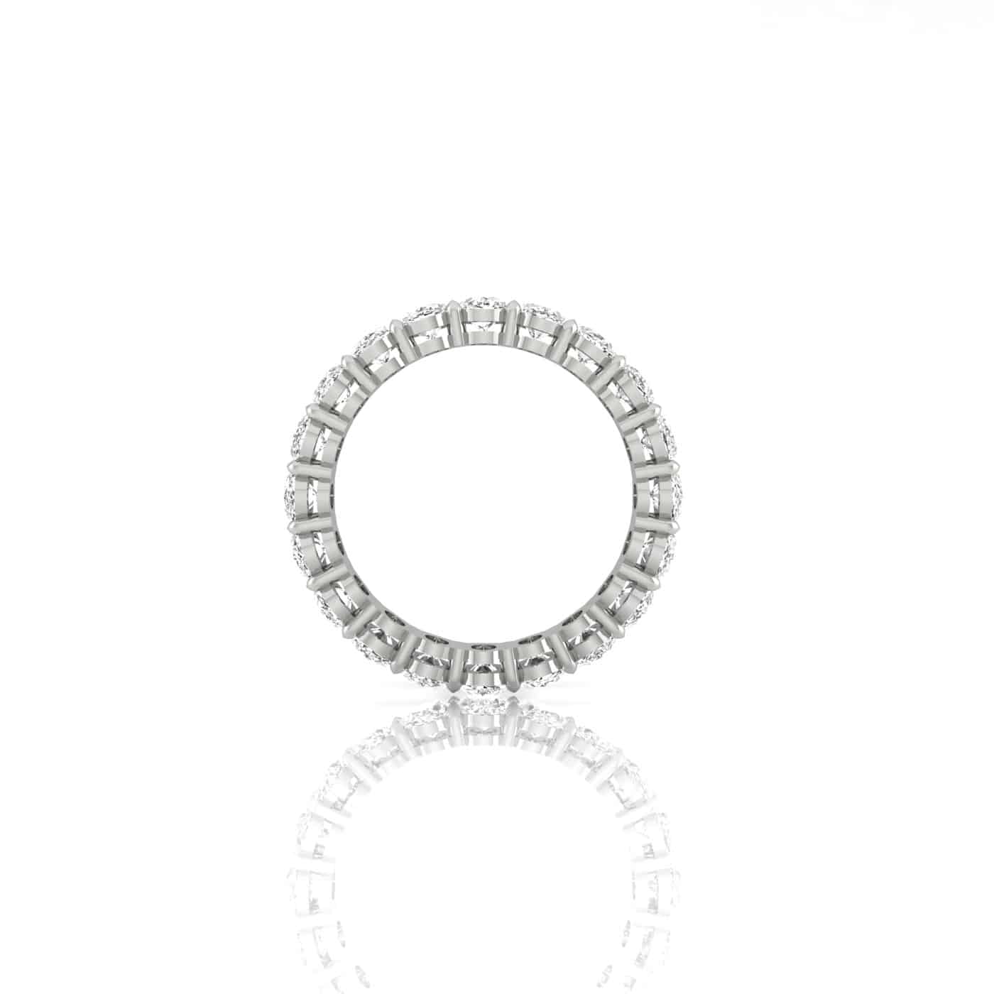 The Test - Full Diamond Eternity Ring, featuring round and baguette-cut F color VS clarity diamonds set in platinum all the way around, is displayed upright on a white reflective surface, exemplifying the sophistication of a custom made diamond ring.