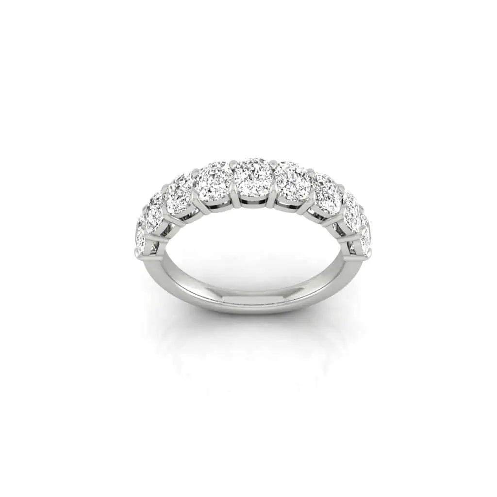 The Half Diamond Eternity Ring, crafted in silver and adorned with VS clarity round diamonds in a prong setting, elegantly decorates the top half of the band against a plain white background.