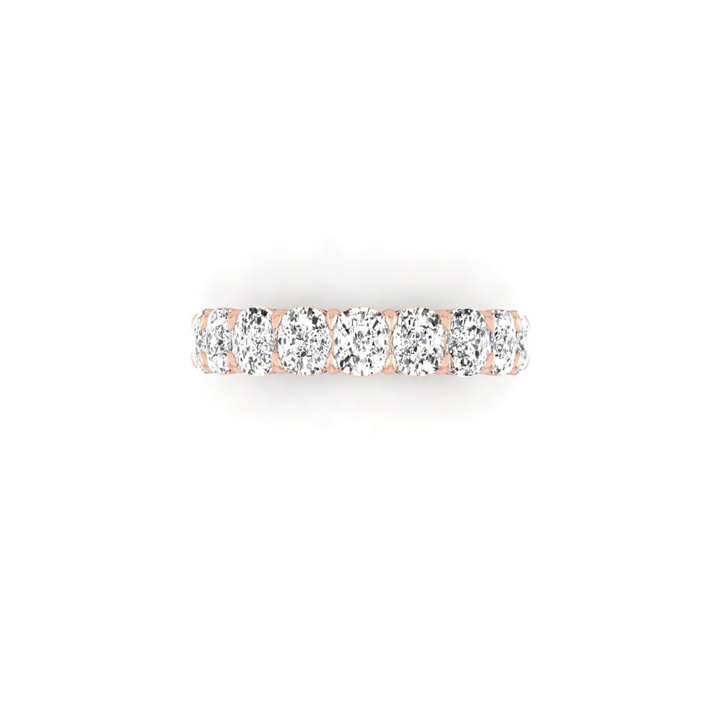 The Half Diamond Eternity Ring features round, brilliant-cut diamonds with VS Clarity in a shared prong setting on an 18KT rose gold band, creating a continuous sparkling effect.