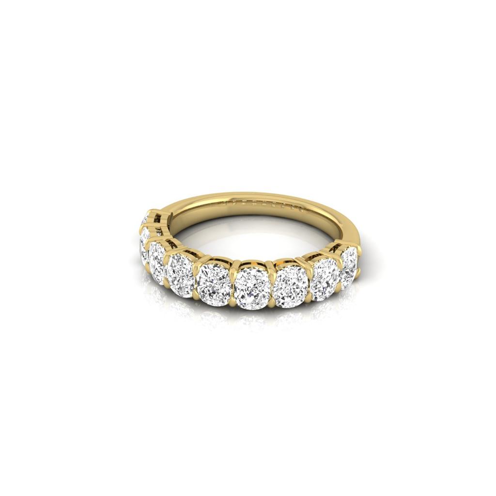 The Half Diamond Eternity Ring features a sleek 18KT polished gold band with round, sparkling diamonds of VS Clarity adorning the upper half. Evenly spaced, these diamonds catch the light beautifully against a plain white background.