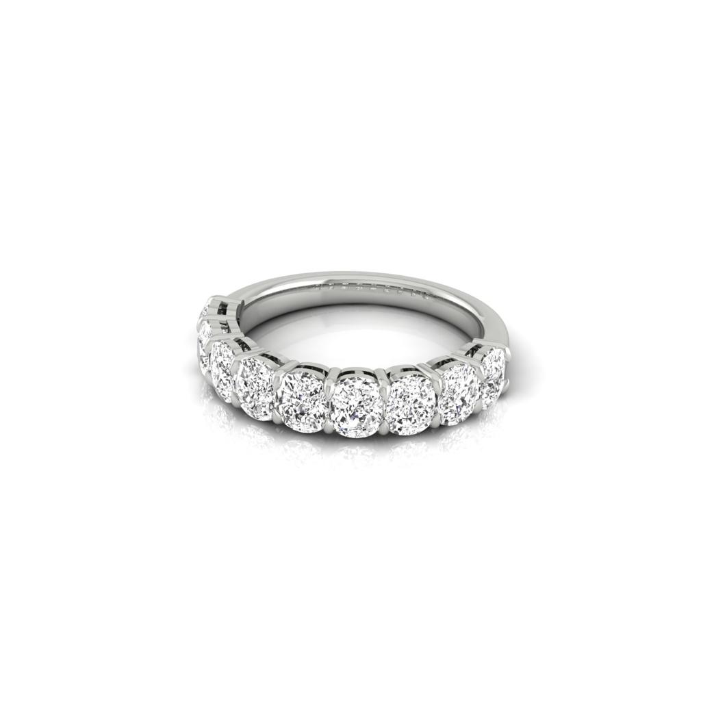 The Half Lab Grown Diamond Eternity Ring features a custom silver band with seven round-cut diamonds set in elegant 18KT gold. Closely arranged, the sparkling diamonds exude luxury against a plain white background, emphasizing the rings exquisite craftsmanship.