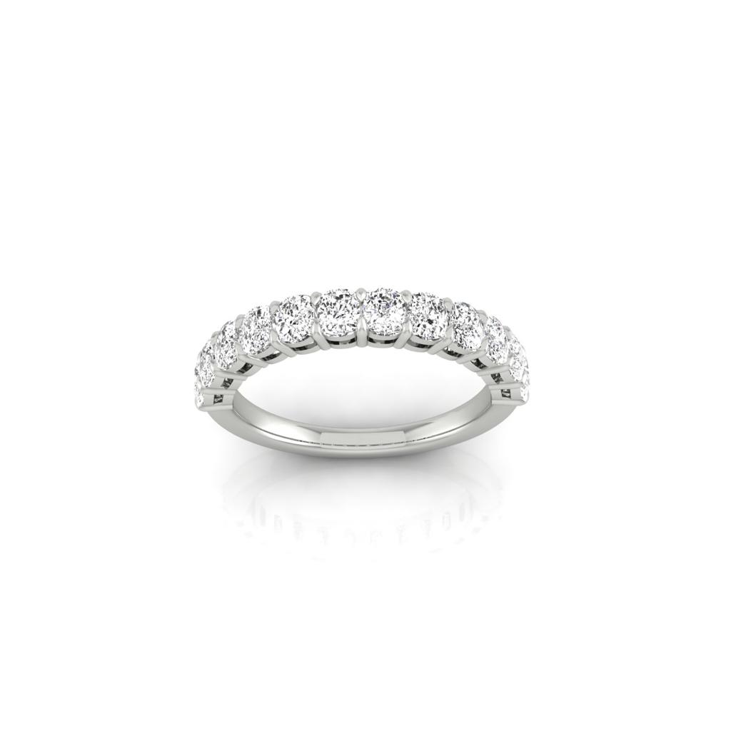 The Half Diamond Eternity Ring is a silver band adorned with slightly raised, round-cut diamonds of VS Clarity along the top. Its simple and elegant, reflecting light beautifully on a white background.