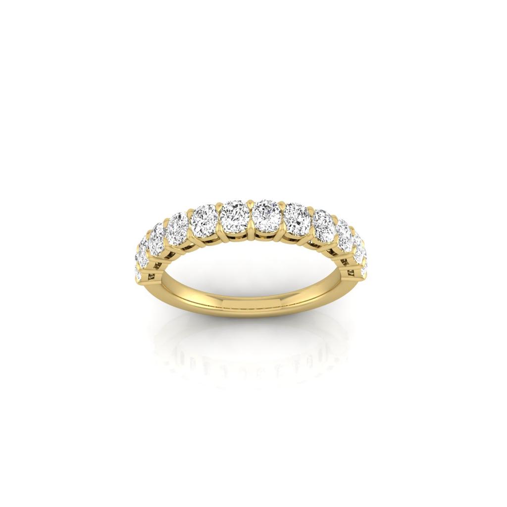 The Half Diamond Eternity Ring, crafted from 18KT gold, showcases a row of sparkling round diamonds on the top half. Displayed upright on a white reflective surface, it perfectly highlights the VS clarity and brilliance of its diamonds.
