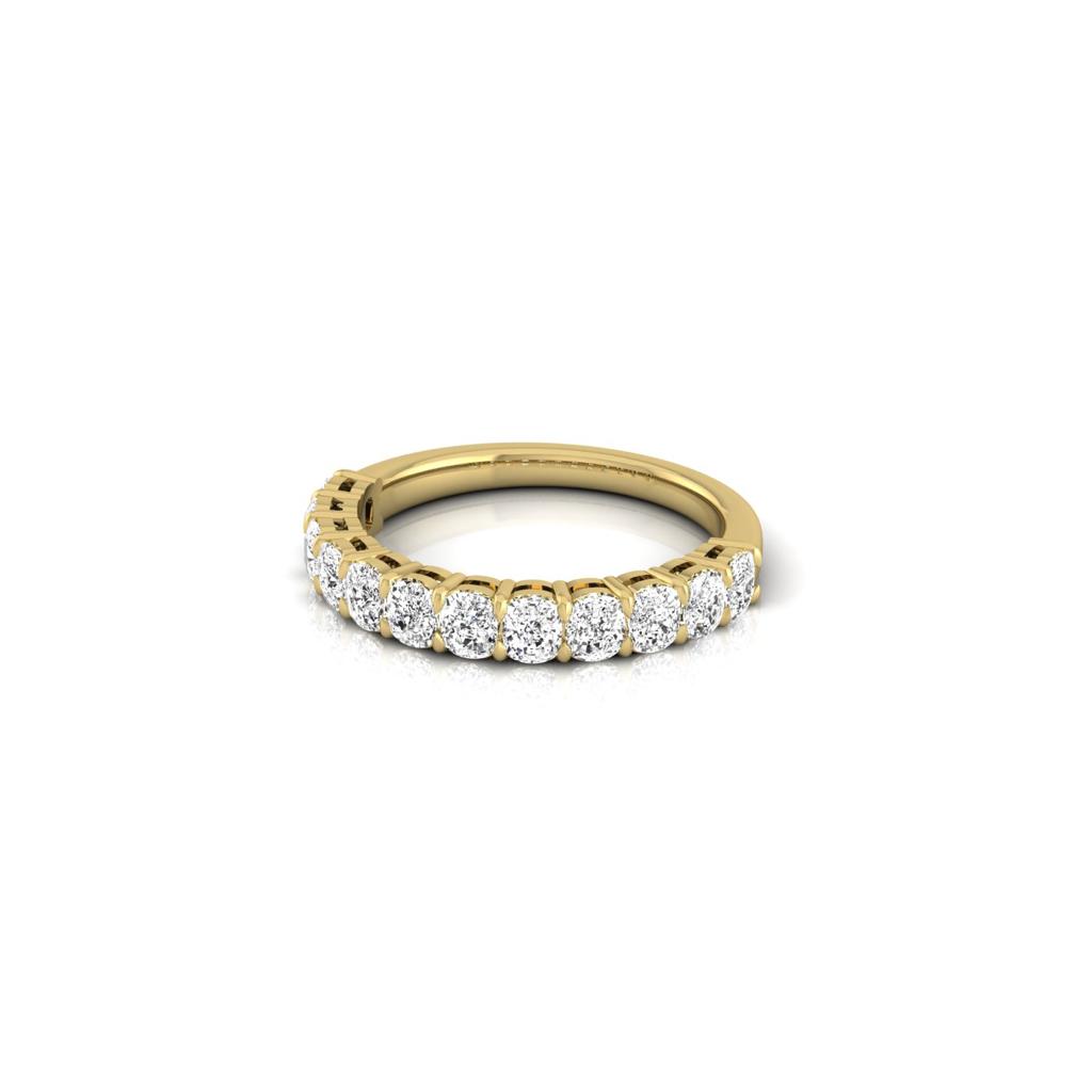 The Half Diamond Eternity Ring features an 18KT gold band adorned with evenly spaced, glittering VS clarity round diamonds on the top half, creating a dazzling effect on a white background.