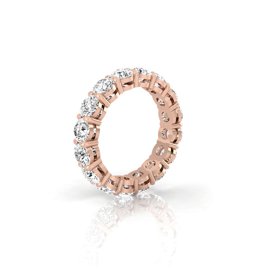 The Full Lab Grown Diamond Eternity Ring, crafted in 18KT rose gold, showcases a continuous circle of large round-cut diamonds in prong settings. The rings reflective surface heightens the brilliance and sparkle of the diamonds, delivering a timeless appeal.