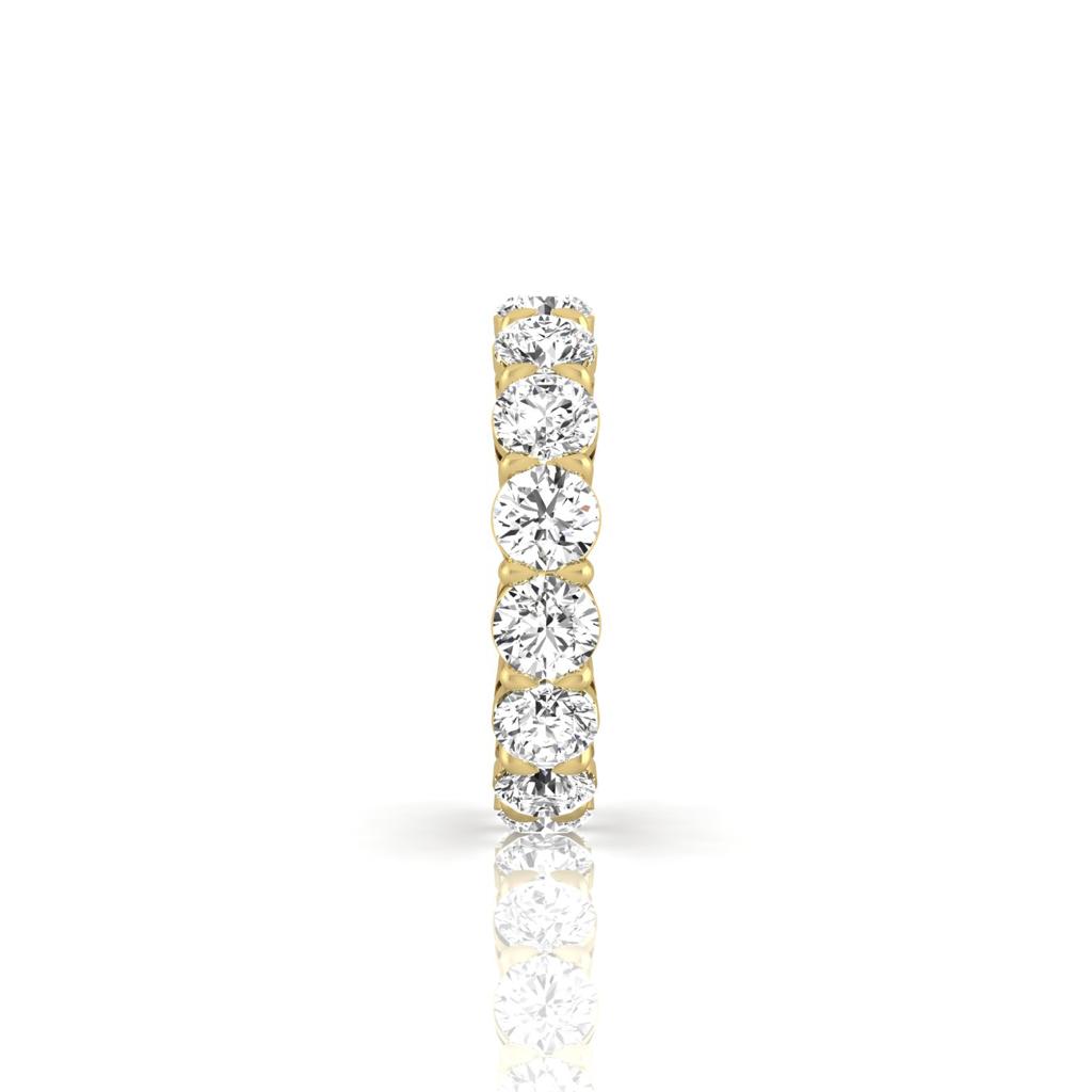 The Full Lab Grown Diamond Eternity Ring showcases brilliant round gems with F Color and VS Clarity, set in a row on lustrous 18KT gold. Against a white background, the diamonds form a sparkling and sophisticated pattern.