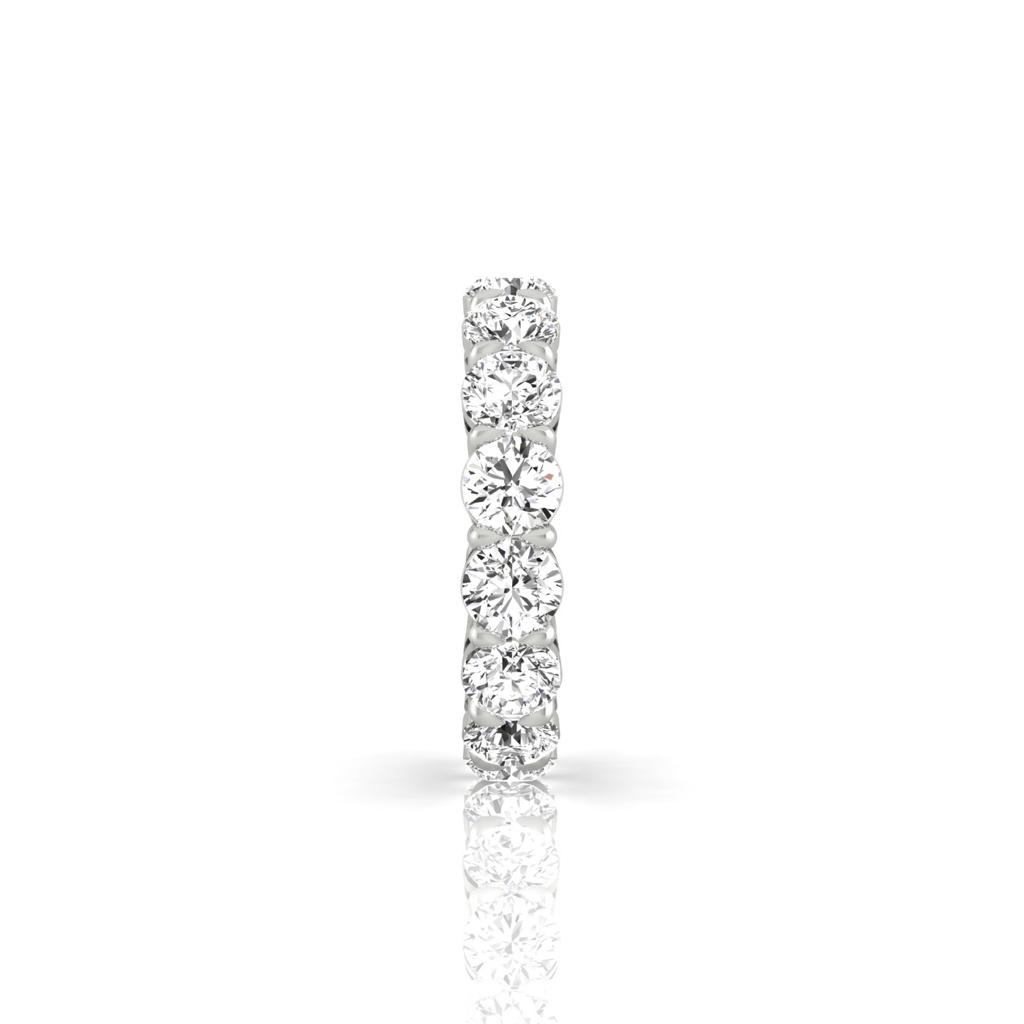 The Full Lab Grown Diamond Eternity Ring, crafted in 18KT gold, features a continuous row of sparkling round diamonds with F color VS clarity that shimmer beautifully against the white surface below.