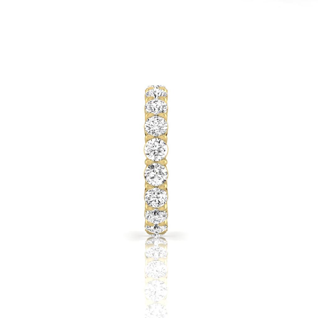 The Full Lab Grown Diamond Eternity Ring is an 18KT gold ring adorned with sparkling round diamonds of F Color and VS Clarity along its upper half, set against a white background with a subtle reflection below.