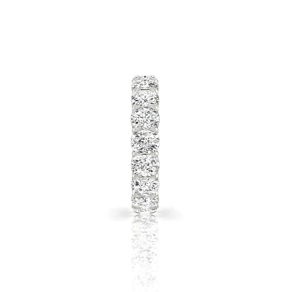An elegant Full Lab Grown Diamond Eternity Ring, crafted in 18KT gold, features a continuous line of F Color VS Clarity round diamonds. Set against a white background, the stones beautifully reflect light, creating a dazzling effect.