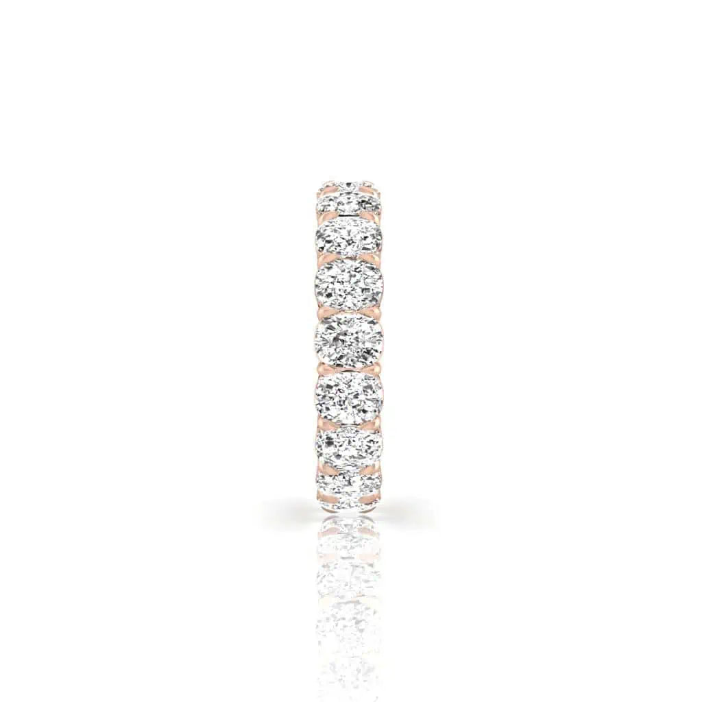 Against a plain white background, the Full Diamond Eternity Ring showcases round, sparkling diamonds in F Color and VS Clarity set in a thin 18KT gold band, reflecting light for a glittering effect.