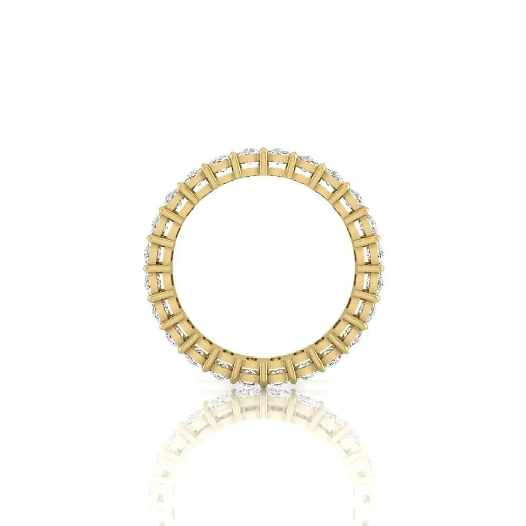 The Full Diamond Eternity Ring, crafted from 18KT gold, features small F Color gemstones set evenly around its band against a plain white backdrop, with a faint reflection below.
