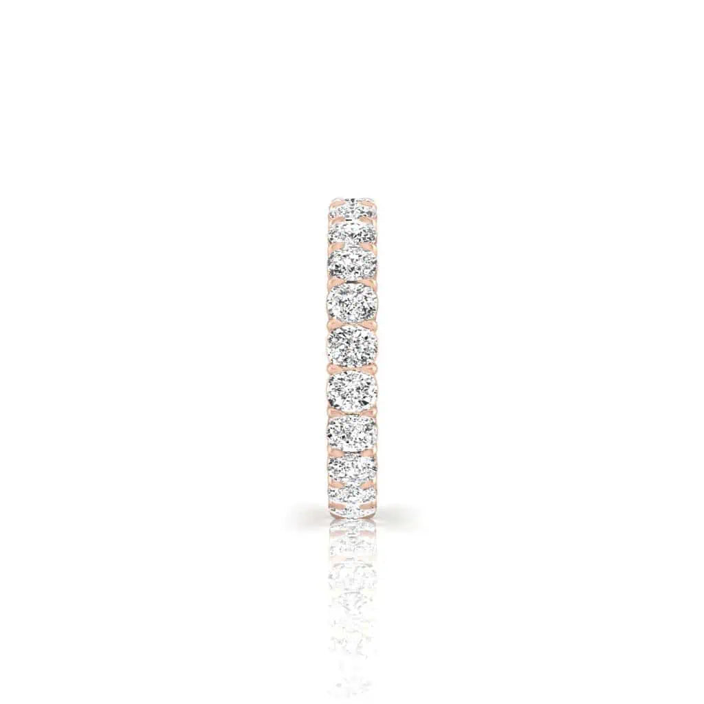 A close-up image of the Full Diamond Eternity Ring, crafted in 18KT rose gold, displayed vertically against a white background. It features F Color diamonds with VS Clarity in a continuous line of sparkling, round-cut stones encircling the band.